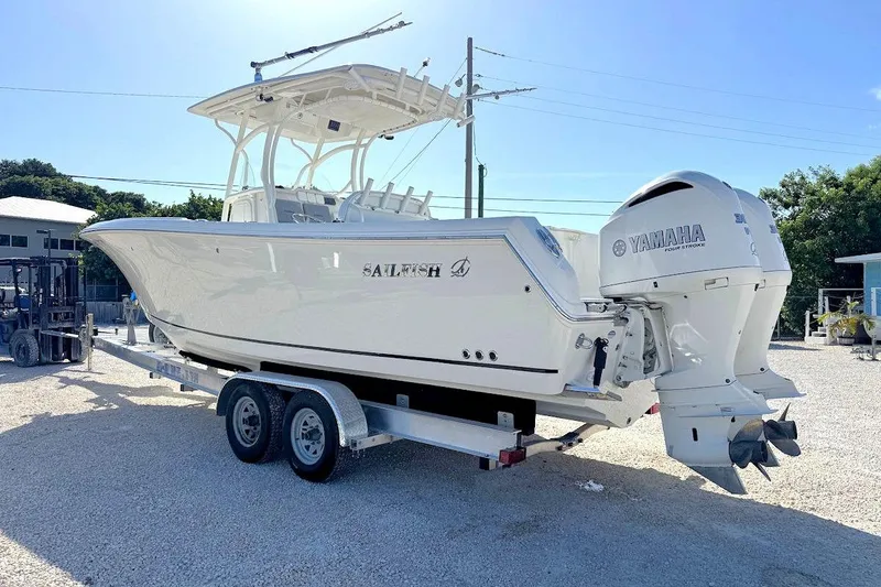 Slide: The Image of 2013 Sailfish 290 CC boat on trailer with Yamaha engines, parked outdoors. - 4