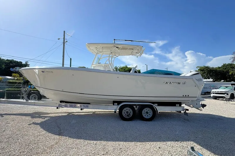 Slide: The Image of 2013 Sailfish 290 CC boat on trailer under clear blue sky. - 5