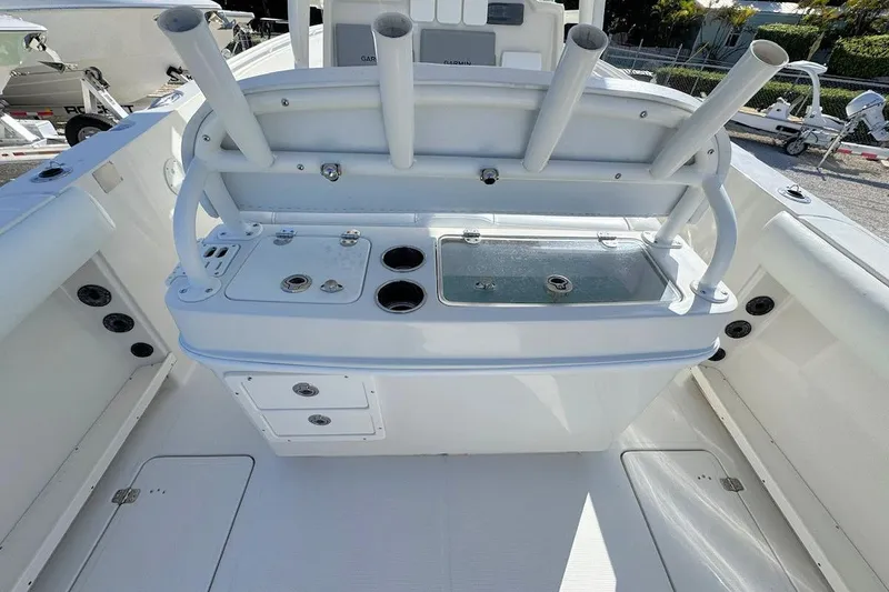Slide: The Image of 2013 Sailfish 290 CC boat interior with rod holders and storage compartments. - 8