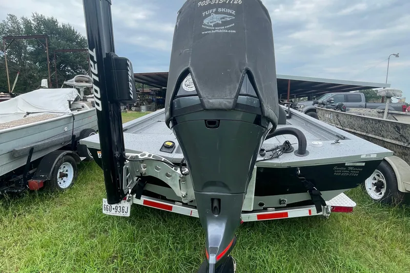 Slide: The Image of 2017 Xpress X21 boat with motor cover, parked on grass near trailers. - 10