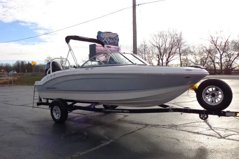 Slide: The Image of 2024 Chaparral 19 SSi OB boat on trailer, parked outdoors on a sunny day. - 2