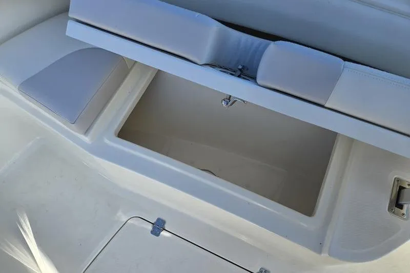Slide: The Image of 2021 Mako 236 CC boat storage compartment with cushioned seating. - 12