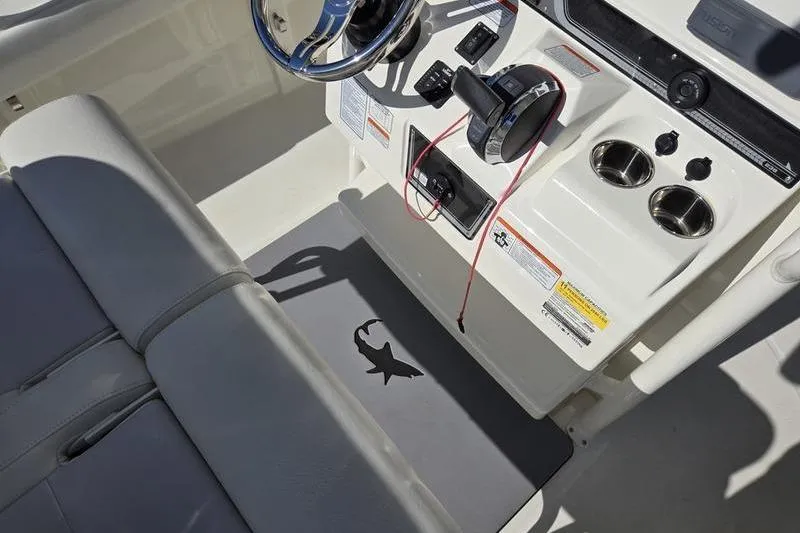 Slide: The Image of 2021 Mako 236 CC boat console with steering wheel and controls. - 13