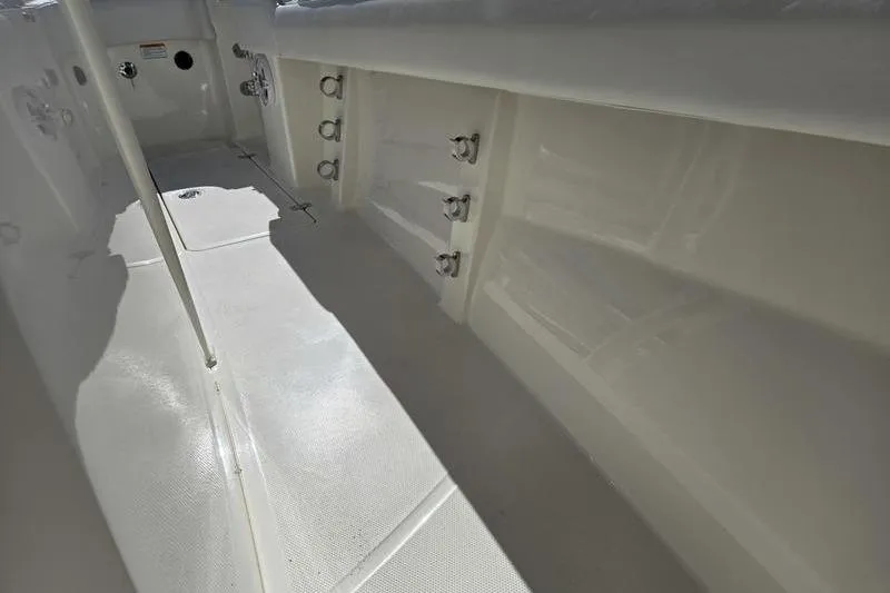 Slide: The Image of 2021 Mako 236 CC boat interior, showcasing rod holders and clean deck design. - 14
