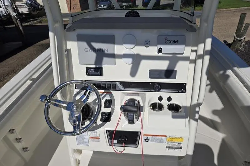 Slide: The Image of 2021 Mako 236 CC boat console with Garmin and Icom equipment, steering wheel, and controls. - 15