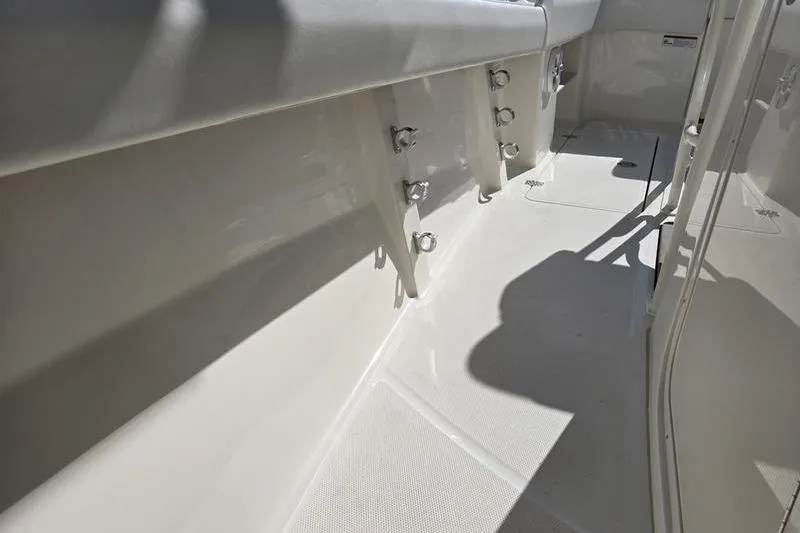 Slide: The Image of 2021 Mako 236 CC boat interior, showcasing clean deck and rod holders. - 16