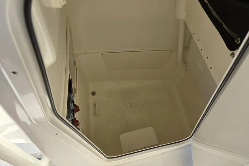 Slide: The Image of 2021 Mako 236 CC boat interior storage compartment, white and spacious design. - 18