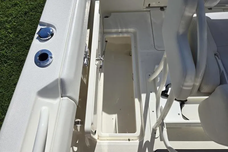 Slide: The Image of 2021 Mako 236 CC boat interior with open storage compartment and seating. - 19