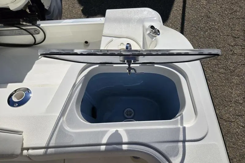 Slide: The Image of 2021 Mako 236 CC boat livewell with open lid, showcasing interior design. - 23