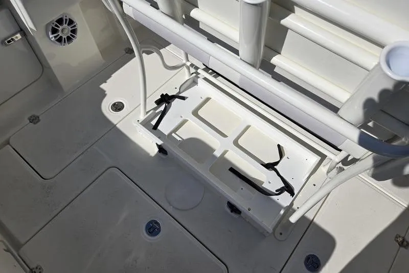 Slide: The Image of 2021 Mako 236 CC boat interior with storage compartment and rod holders. - 28