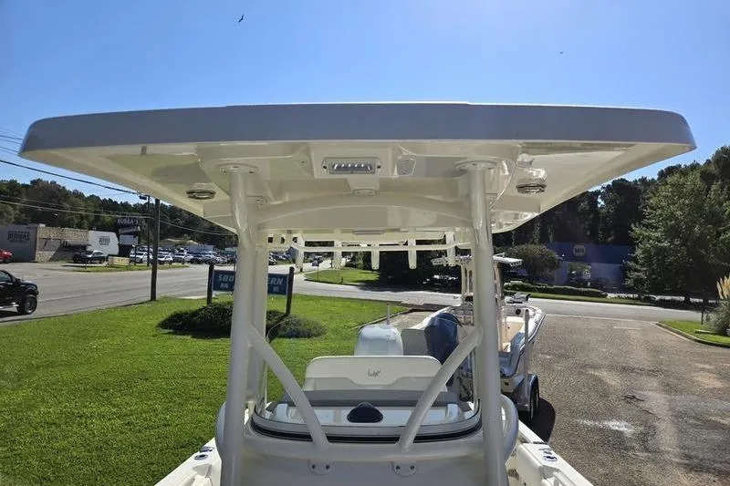 Slide: The Image of 2021 Mako 236 CC boat with T-top, parked outdoors on a sunny day. - 9
