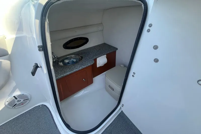 Slide: The Image of 2005 Chaparral 260 SSi boat interior with sink, toilet, and storage cabinet. - 13