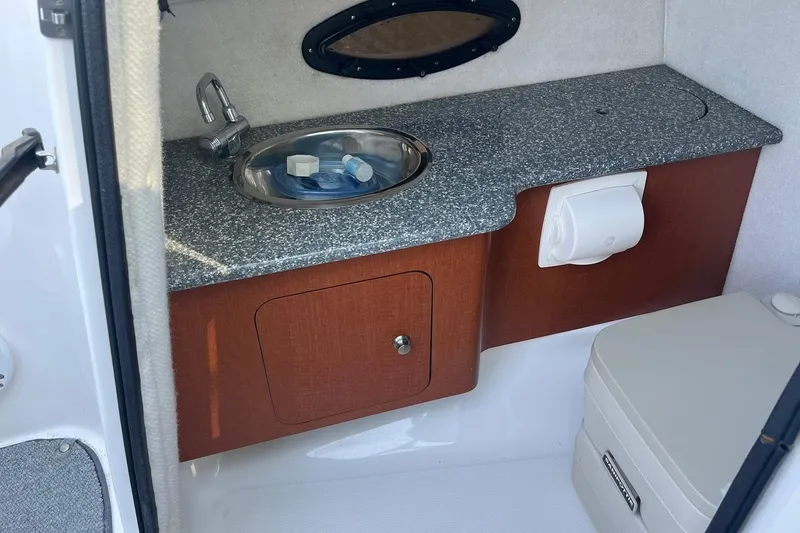 Slide: The Image of 2005 Chaparral 260 SSi boat interior with sink, countertop, and storage cabinet. - 14