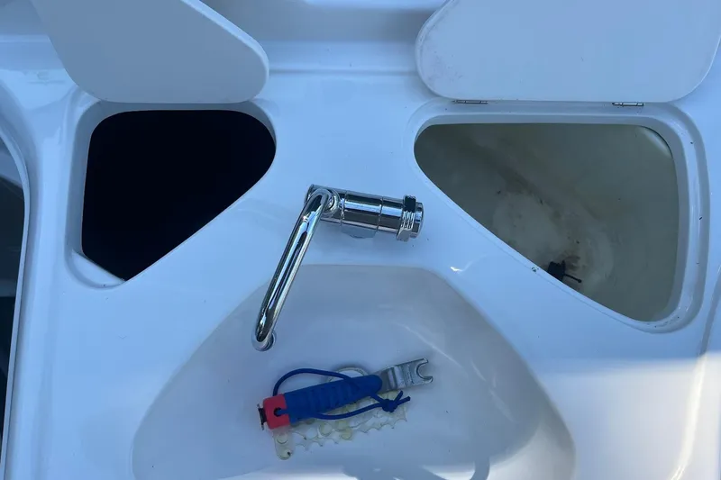 Slide: The Image of 2005 Chaparral 260 SSi boat interior with faucet and storage compartments. - 22