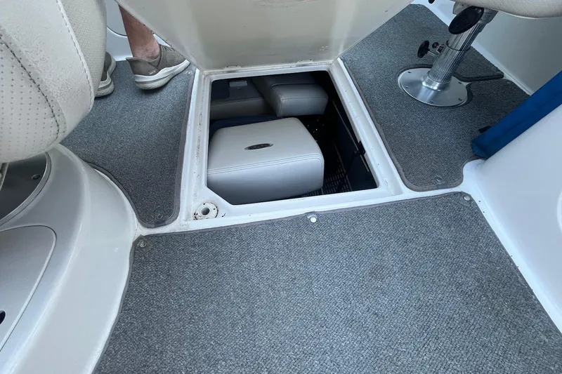 Slide: The Image of 2005 Chaparral 260 SSi boat interior with open storage compartment and seating. - 24
