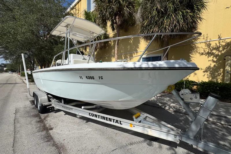 Slide: The Image of 1988 Pursuit C 200 Center Console boat on trailer, parked on a sunny street. - 1
