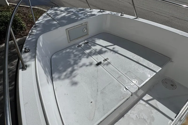 Slide: The Image of 1988 Pursuit C 200 Center Console boat deck with storage compartment, docked on a sunny day. - 4