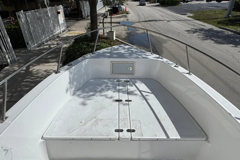 Slide: The Image of 1988 Pursuit C 200 Center Console boat on a street, showing bow area and railings. - 5