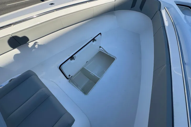 Slide: The Image of 2026 Cape Horn 31 T boat interior with open storage compartment and cushioned seating. - 23