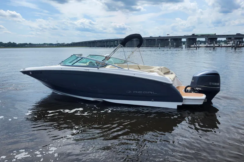 The Image of 2019 Regal 23 OBX boat with Yamaha engine on calm water near a bridge. - 0