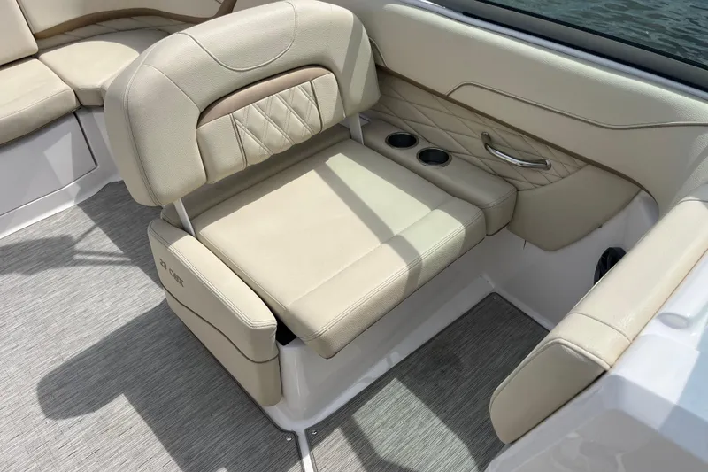 Slide: The Image of 2019 Regal 23 OBX boat interior with beige seating and steering wheel on water. - 10