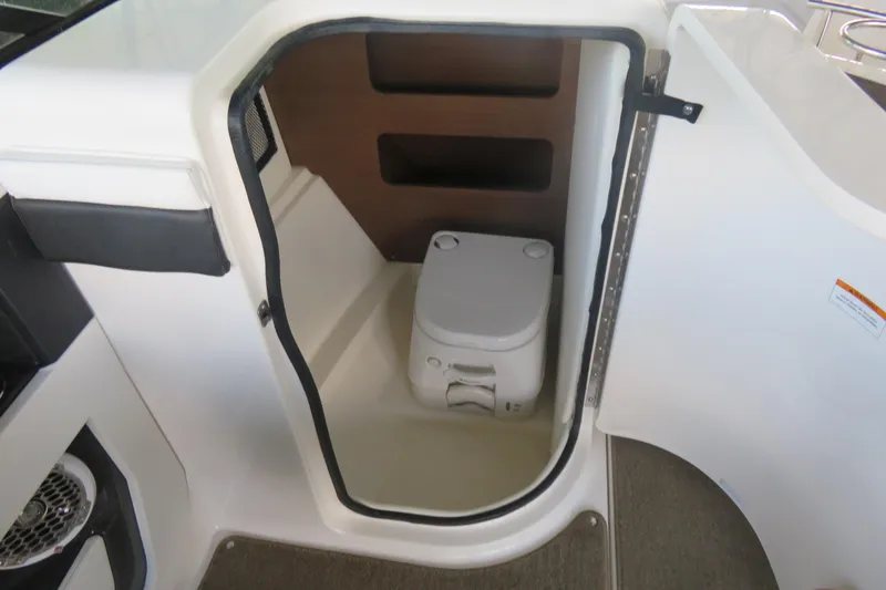 Slide: The Image of 2014 Sea Ray 220 Sundeck Outboard boat interior with compact marine toilet. - 5
