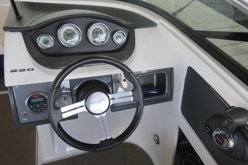 Slide: The Image of 2014 Sea Ray 220 Sundeck Outboard dashboard with steering wheel and gauges. - 6