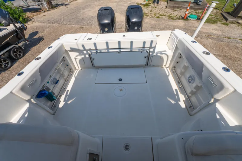 Slide: The Image of 2010 Triton 301XD boat with dual outboard motors, viewed from the rear on a sunny day. - 10