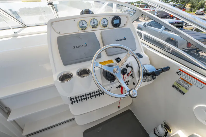 Slide: The Image of Interior of 2010 Triton 301XD boat with white seating and steps. - 17