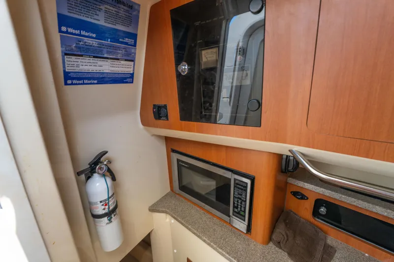 Slide: The Image of Interior of 2010 Triton 301XD boat with kitchenette, sink, and wooden steps. - 24