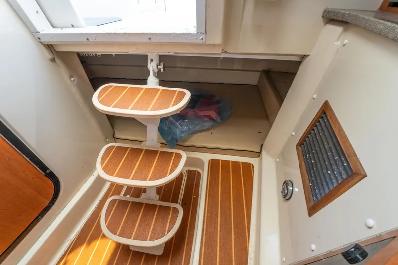 Slide: The Image of 2010 Triton 301XD interior with microwave, fire extinguisher, and wooden cabinetry. - 25