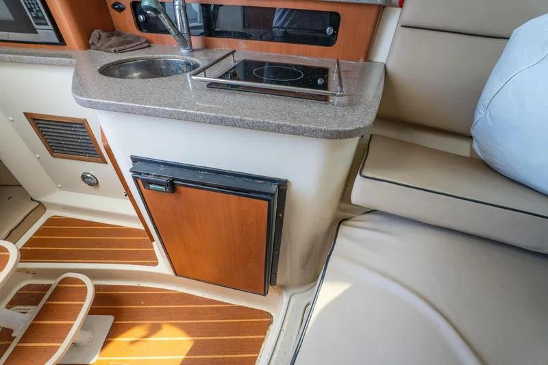 Slide: The Image of Interior of 2010 Triton 301XD boat with wooden steps and storage area. - 26