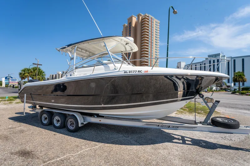 Slide: The Image of 2010 Triton 301XD boat on trailer, urban background, clear sky. - 3