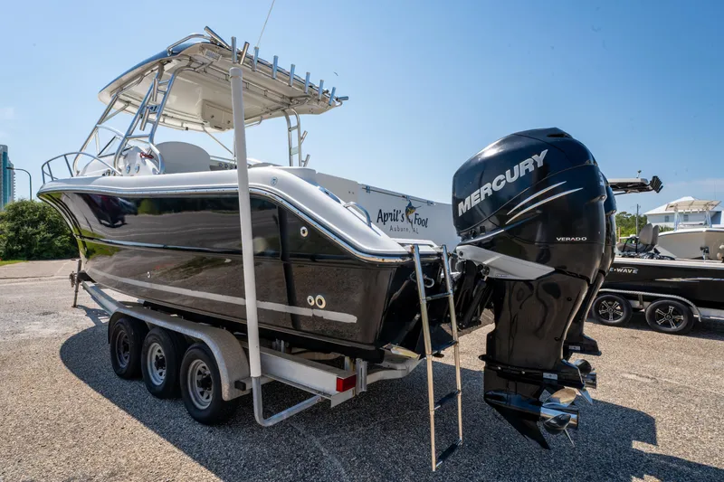 Slide: The Image of 2010 Triton 301XD boat with dual 300 Verado engines, parked on a sunny day. - 6