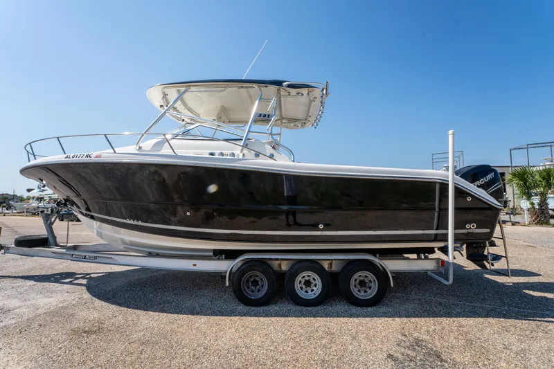 Slide: The Image of 2010 Triton 301XD boat on trailer with Mercury Verado engine, parked outdoors. - 7