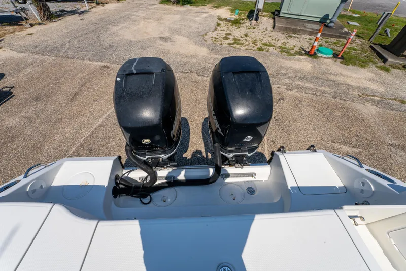 Slide: The Image of 2010 Triton 301XD boat on trailer, parked outdoors under clear blue sky. - 9