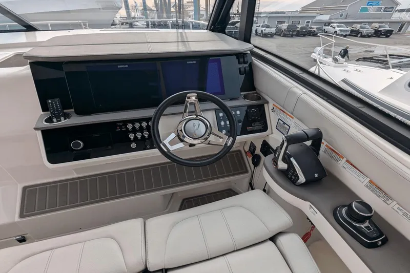 Slide: The Image of 2023 Sea Ray Sundancer 320 Outboard helm with modern controls and navigation displays. - 10