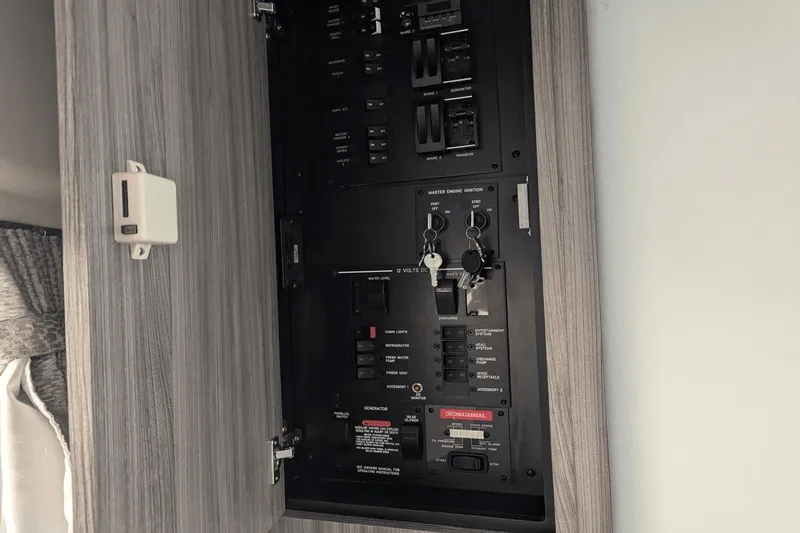 Slide: The Image of Electrical panel inside 2023 Sea Ray Sundancer 320 Outboard, featuring switches and keys. - 11