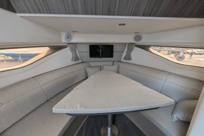 Slide: The Image of Interior of 2023 Sea Ray Sundancer 320 Outboard, featuring a modern, spacious cabin with seating. - 14
