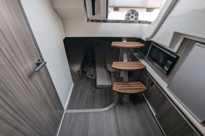 Slide: The Image of 2023 Sea Ray Sundancer 320 Outboard cabin interior with modern wood finish and compact design. - 18