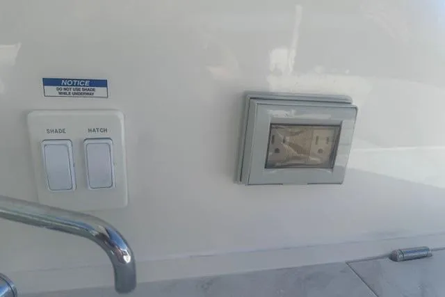 Slide: The Image of Control panel on 2023 Sea Ray Sundancer 320 Outboard boat, featuring shade and hatch switches. - 20