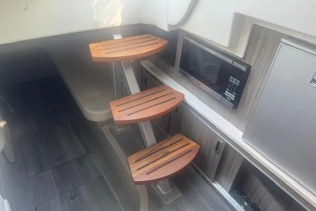Slide: The Image of 2023 Sea Ray Sundancer 320 Outboard interior with wooden steps and modern amenities. - 24