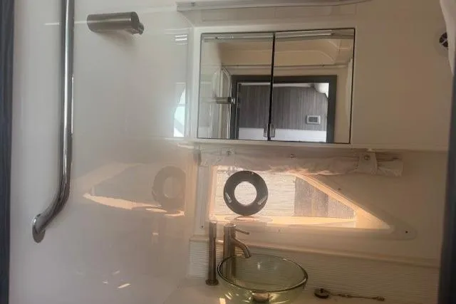 Slide: The Image of 2023 Sea Ray Sundancer 320 Outboard bathroom interior with modern fixtures and glass sink. - 25