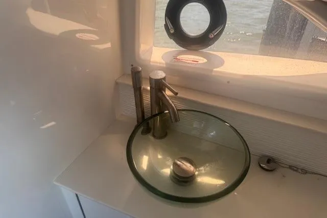 Slide: The Image of 2023 Sea Ray Sundancer 320 Outboard bathroom with modern glass sink and sleek faucet design. - 26