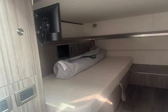 Slide: The Image of 2023 Sea Ray Sundancer 320 Outboard cabin interior with bed and mounted TV. - 30