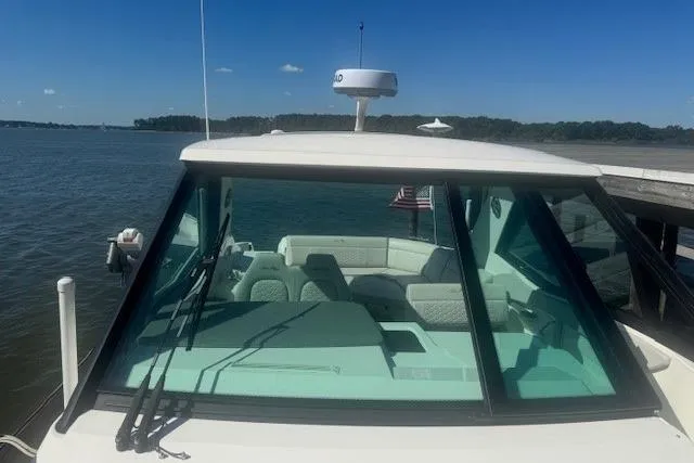 Slide: The Image of 2023 Sea Ray Sundancer 320 Outboard on calm water, showcasing sleek design and spacious interior. - 33