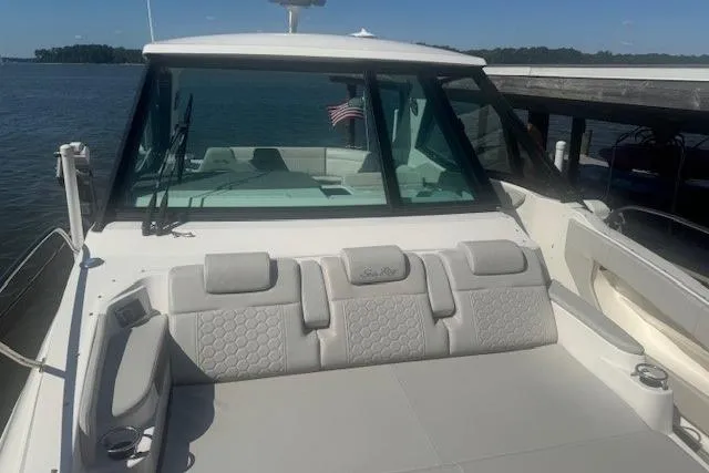 Slide: The Image of 2023 Sea Ray Sundancer 320 Outboard boat with spacious seating, docked by the water. - 34