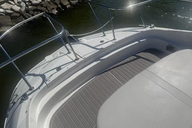 Slide: The Image of 2023 Sea Ray Sundancer 320 Outboard boat deck with railing, near rocky shoreline. - 35