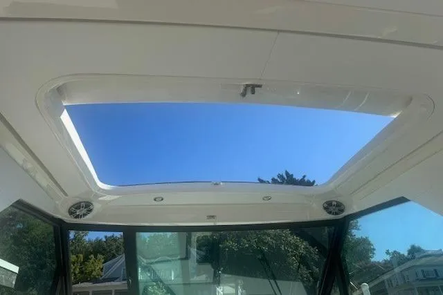 Slide: The Image of 2023 Sea Ray Sundancer 320 Outboard sunroof view with clear blue sky. - 37