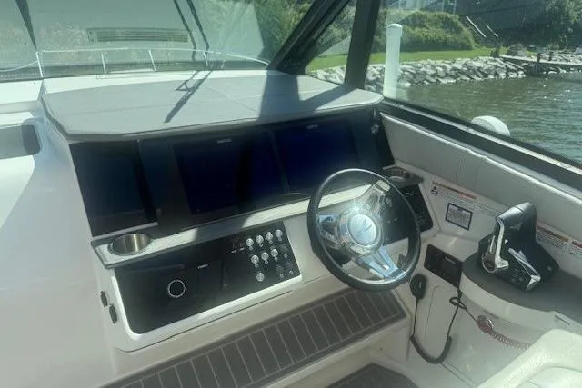 Slide: The Image of 2023 Sea Ray Sundancer 320 Outboard helm with modern controls and steering wheel. - 41